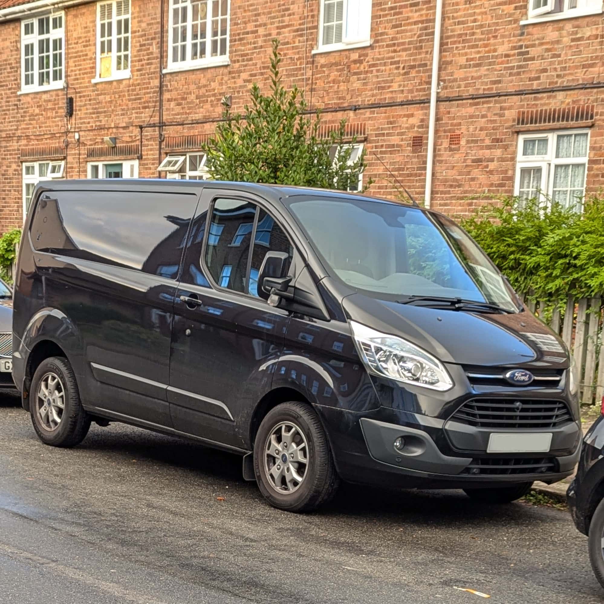 Black Ford Transit Custom parked on the kerbside