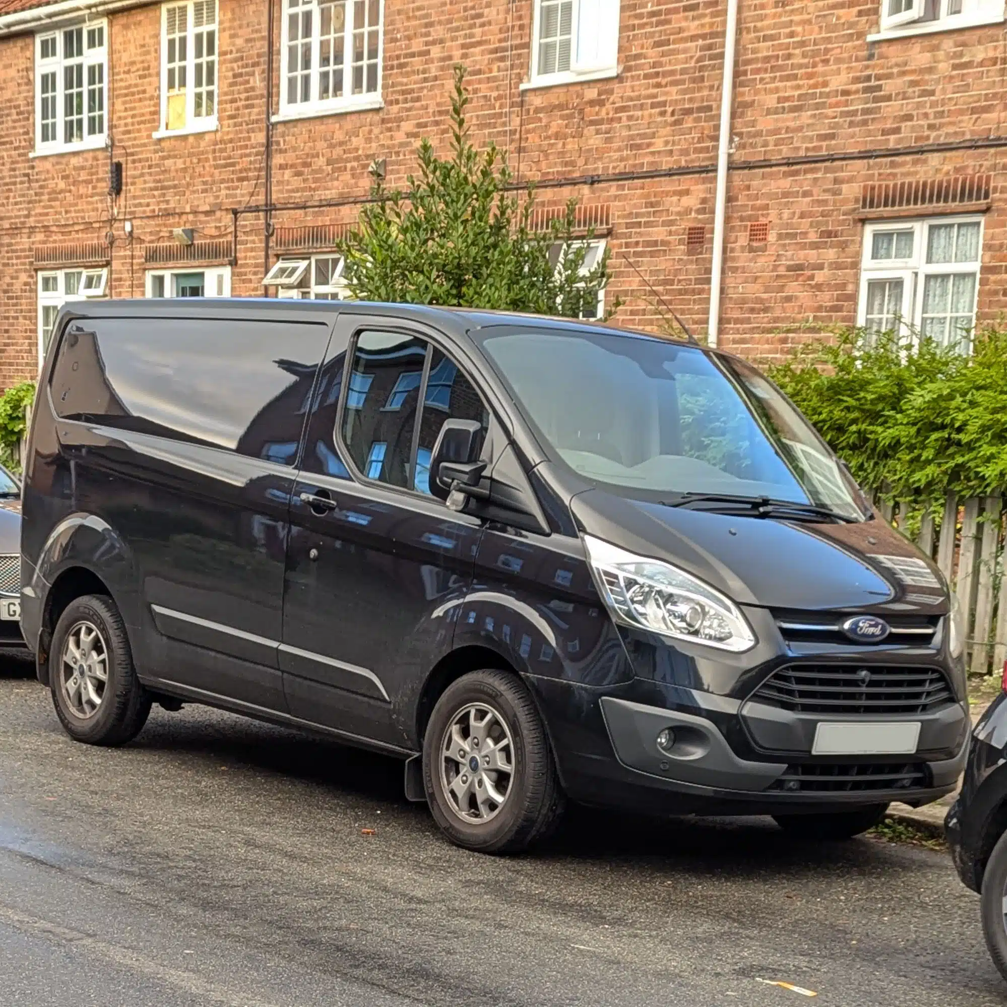 Black Ford Transit Custom parked on the kerbside