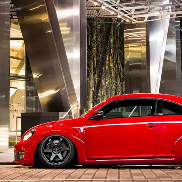 Lowered red VW Beetle A5 parked outside a building