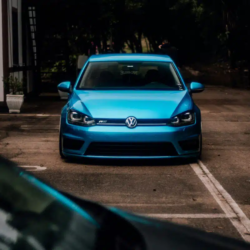 Lowered blue VW Golf R in a parking lot