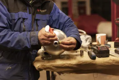 An AirRide technician using thread sealant