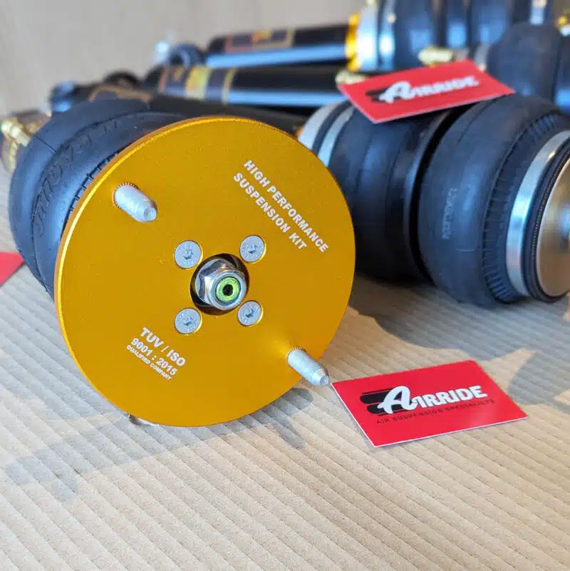 Close up of an AirRide Gold Nissan Skyline R33 2WD strut on beige background