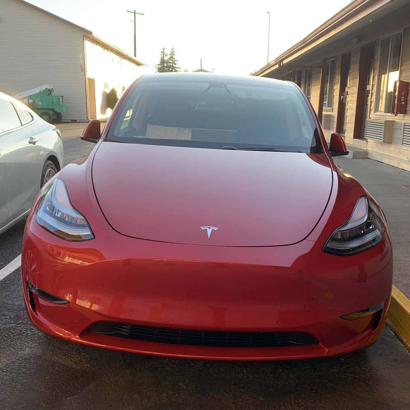 Red Tesla Y shown parked