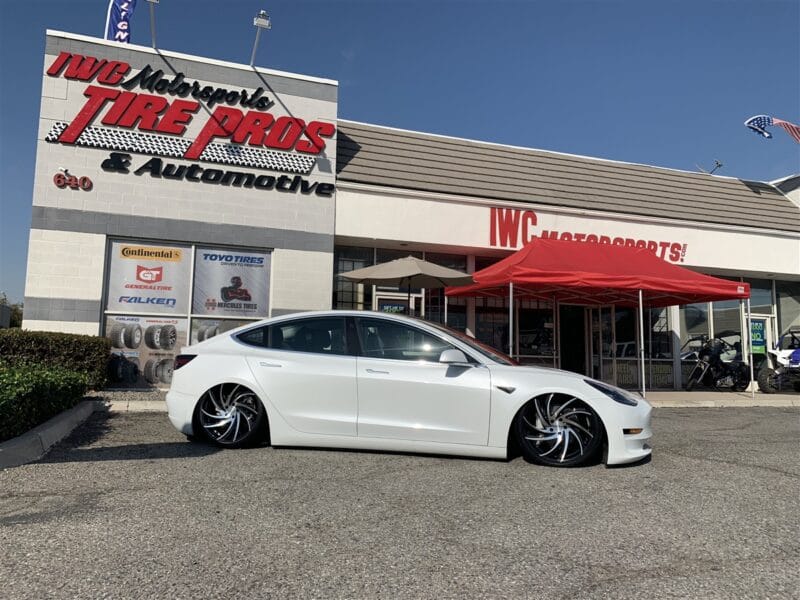White lowered Tesla in front of US Tyre/Tire shop