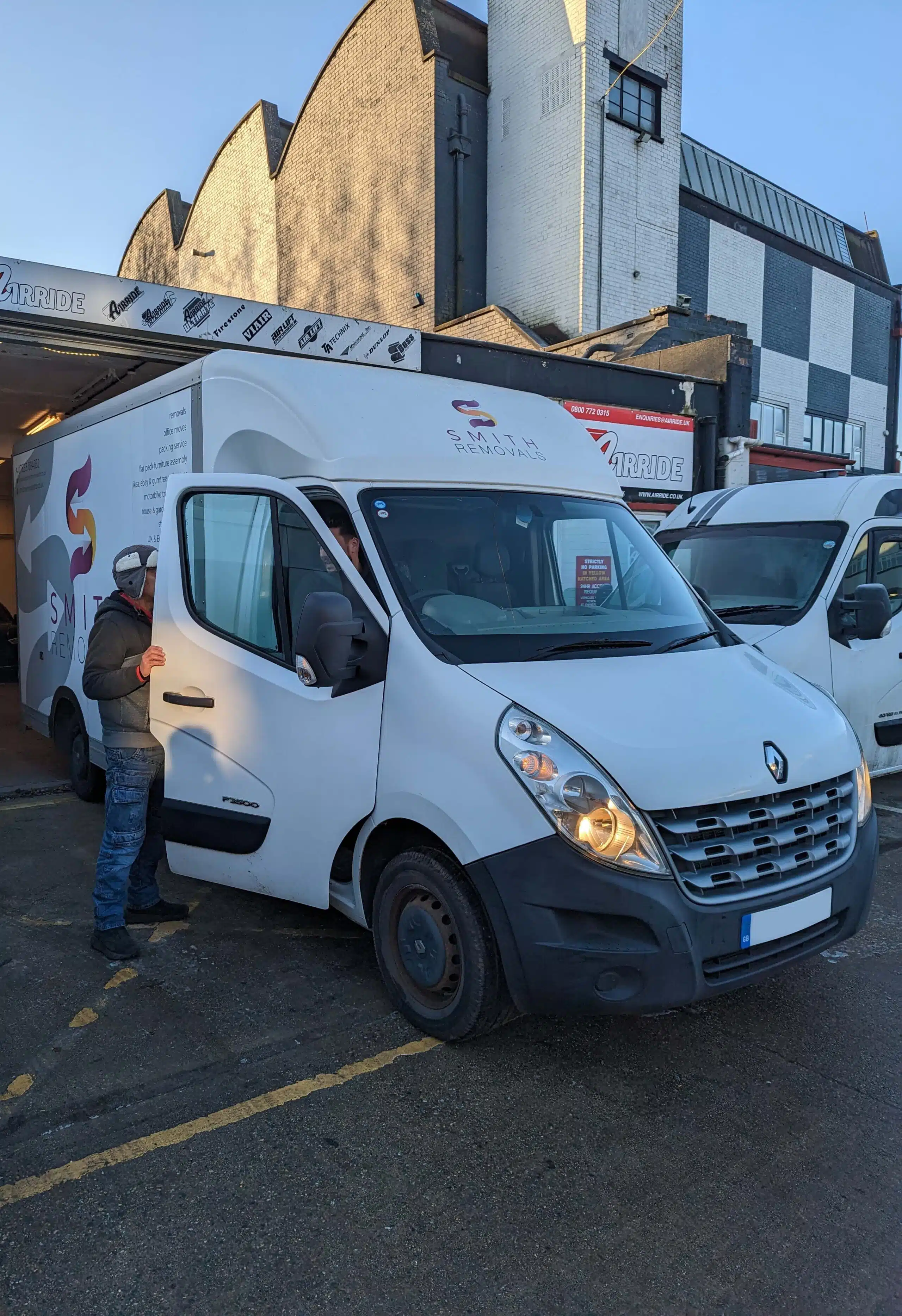Smith Removals Renault Master parked outside AirRide with staff of both companies chatting