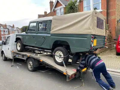 Green Defender 130 on a car transporter that is over the weight limit