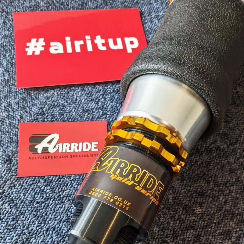 AirRide Gold Mazda MX-5 strut rim close up on blue background