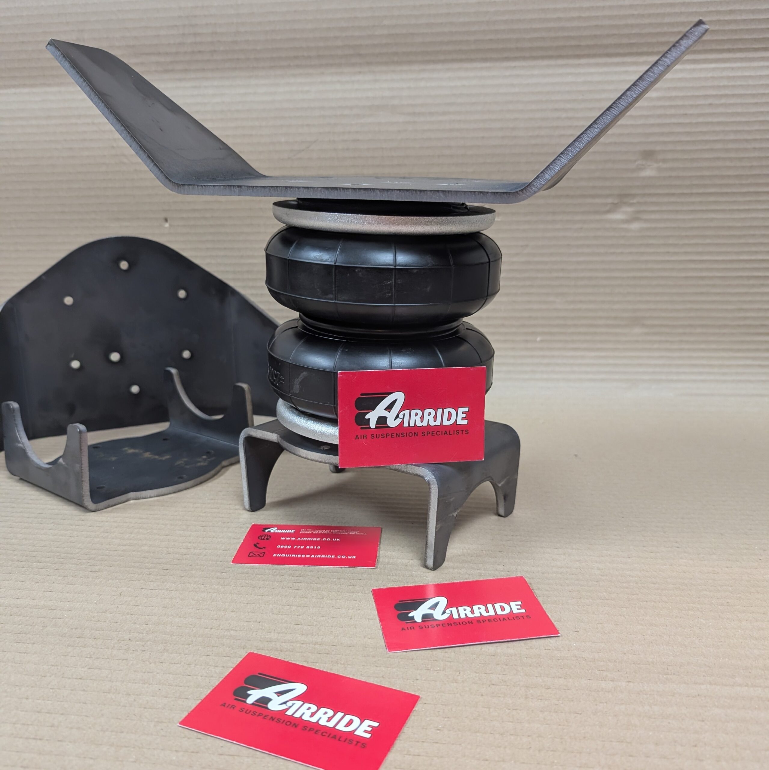 Over axle brackets for Boss 2500 bags shown roughly assembled on beige background