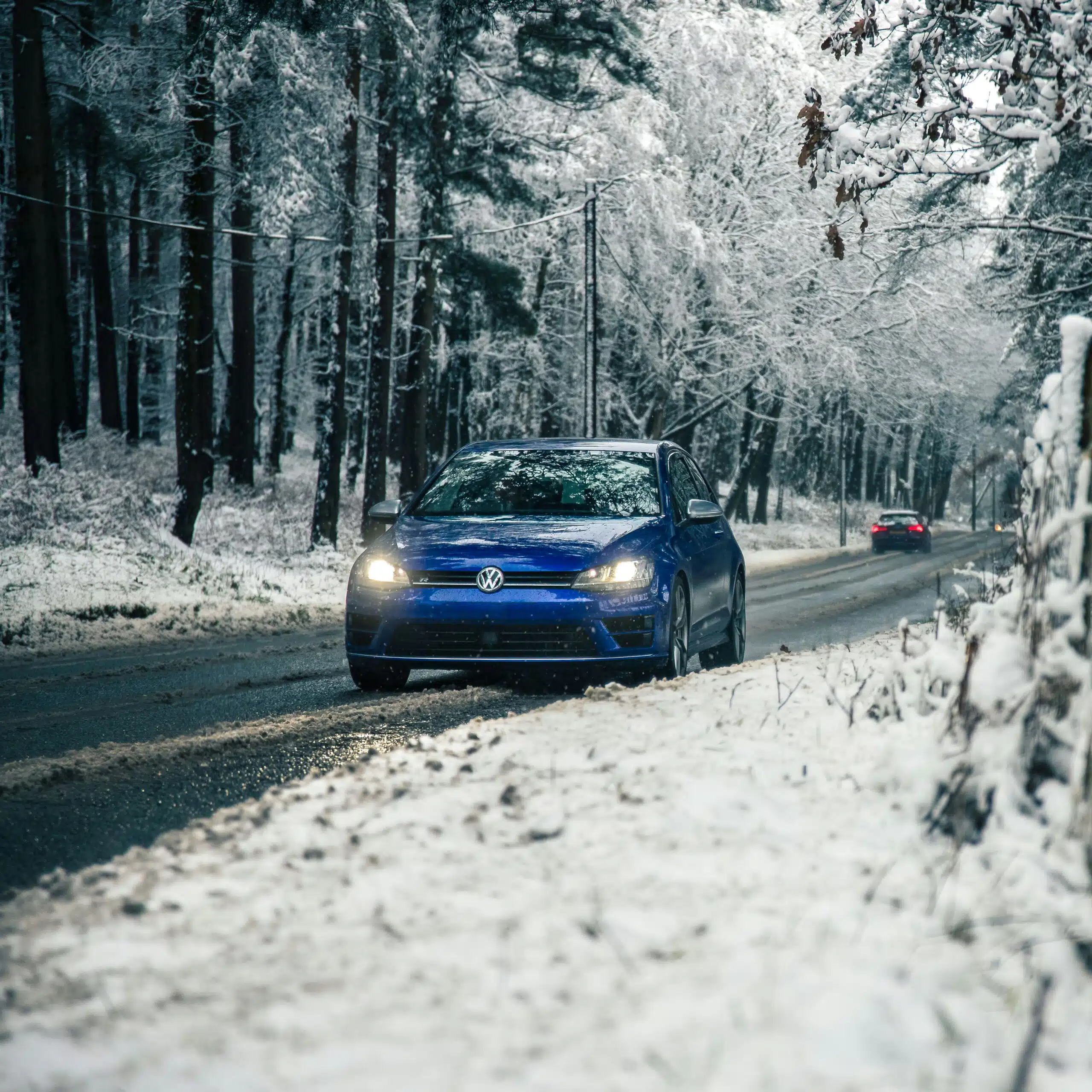 Blue VW Golf driving in snowy conditions